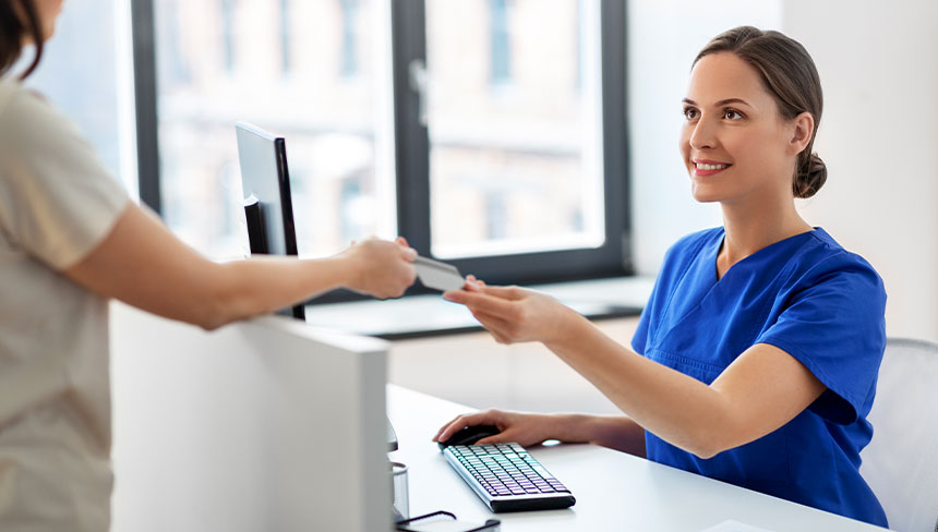 parent making a payment with the receptionist at Back Pain, Neck Pain, & Headache Relief Center in Salinas, CA